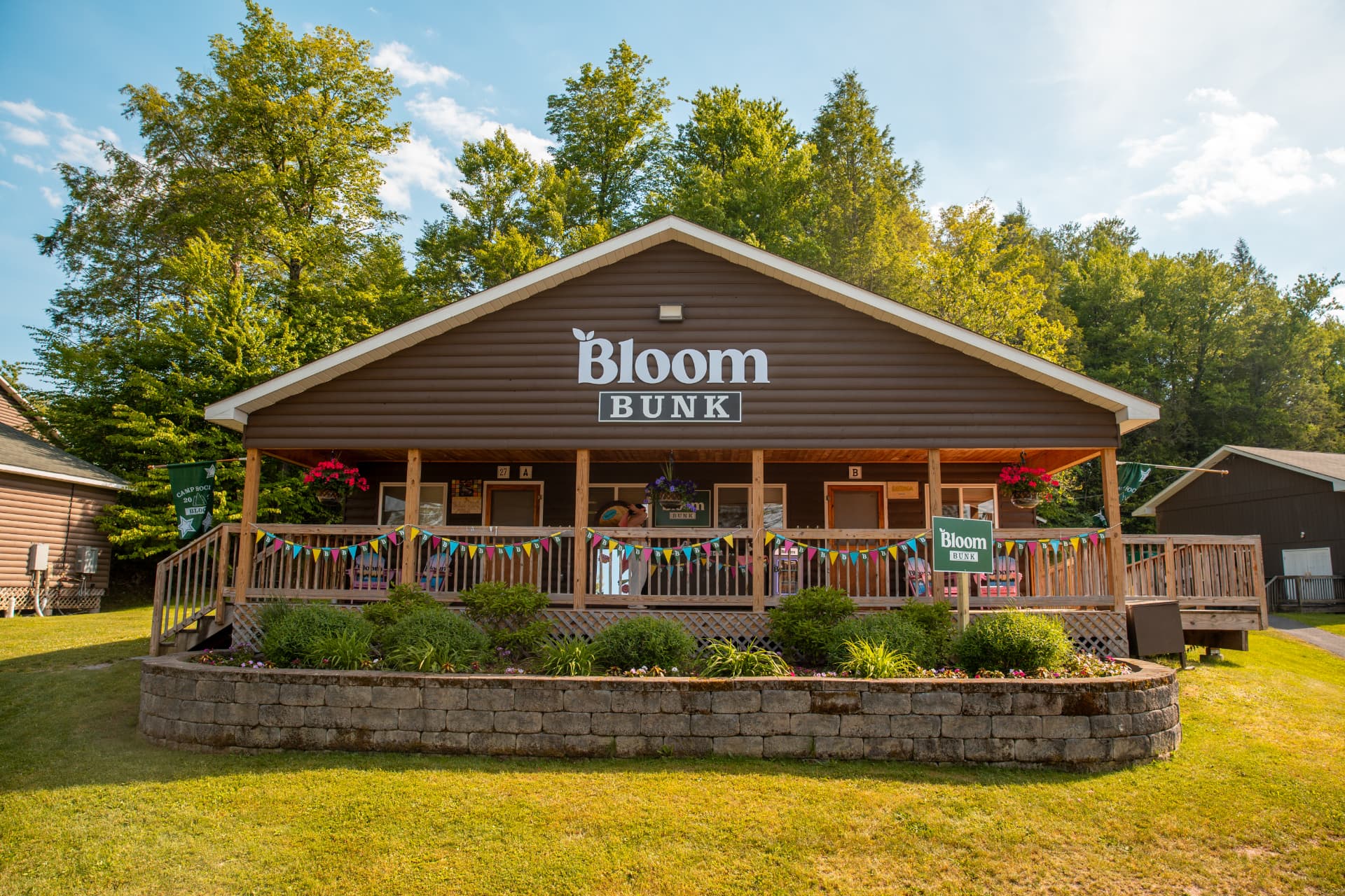 Branded cabin porch at The Acres with custom banners, bunting and yard signage